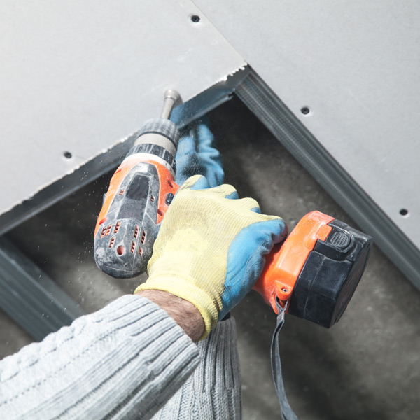 hand holding drill against ceiling
